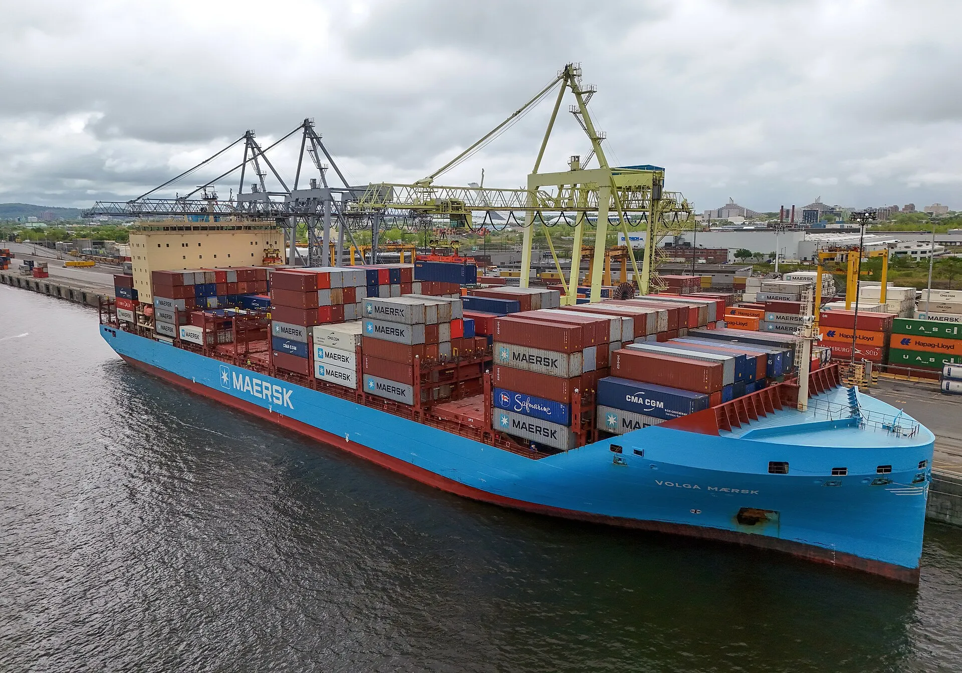 Container ship being maneuvered at a river port